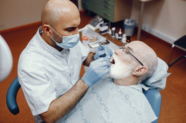 A elderly man undergoing a frenectomy procedure 