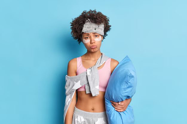 A lady in her pyjama, holding a pillow, as a form a form of illustration for the difficulty in breaking a bad habit 