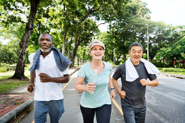 Benefits of regular exercise for older adults. A woman and 2 men running and laughing. 