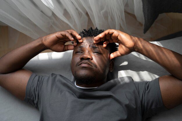 A man laying on the couch in his living room dealing with chronic stress 