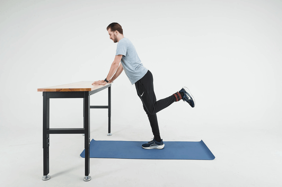 A gif of a man doing standing back kicks exercise. Safe exercises for obese or overweight people